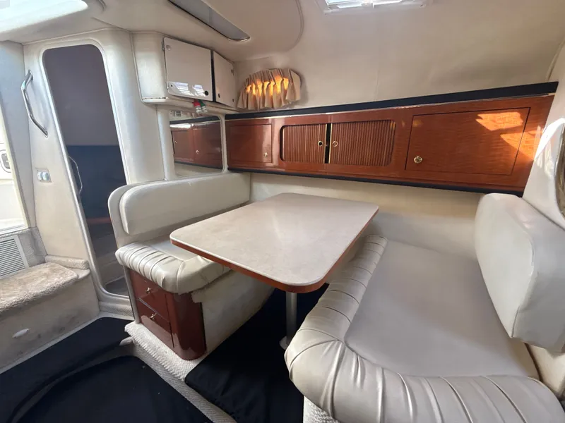 Slide: The Image of 2001 Sea Ray 290 Sundancer cabin interior with dining area and wooden cabinetry. - 25