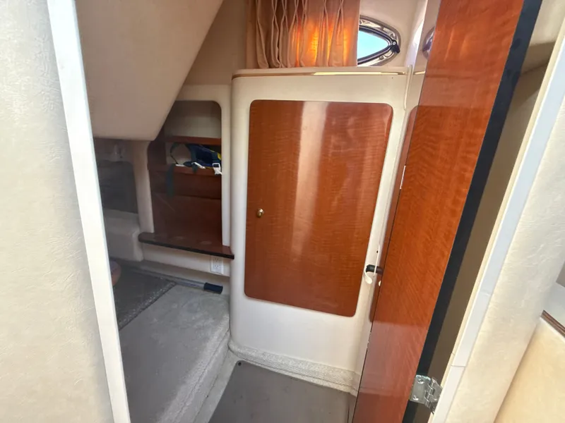 Slide: The Image of Interior cabin of 2001 Sea Ray 290 Sundancer with wood paneling and cozy layout. - 26