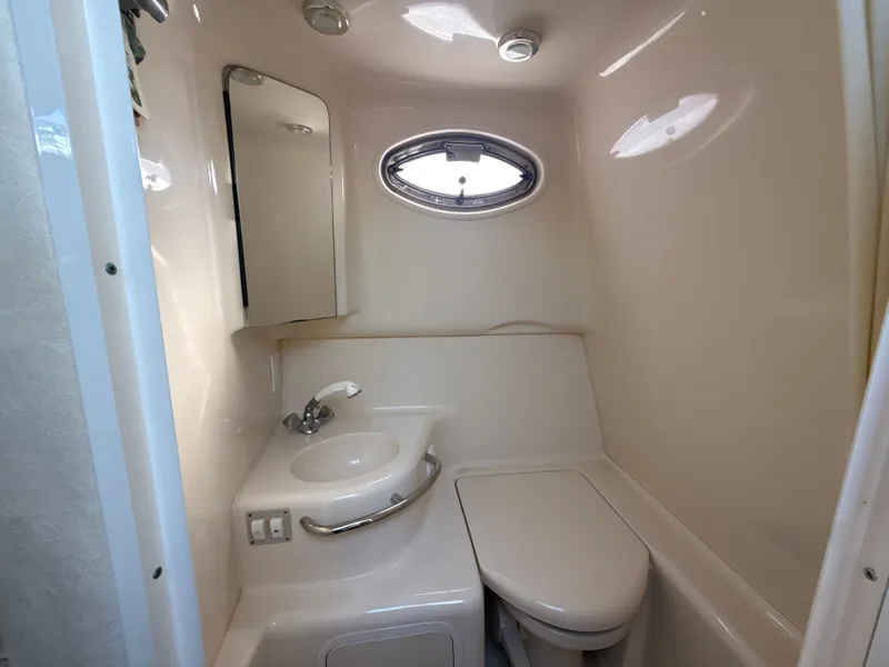 Slide: The Image of 2001 Sea Ray 290 Sundancer bathroom with sink, mirror, and oval window. - 29