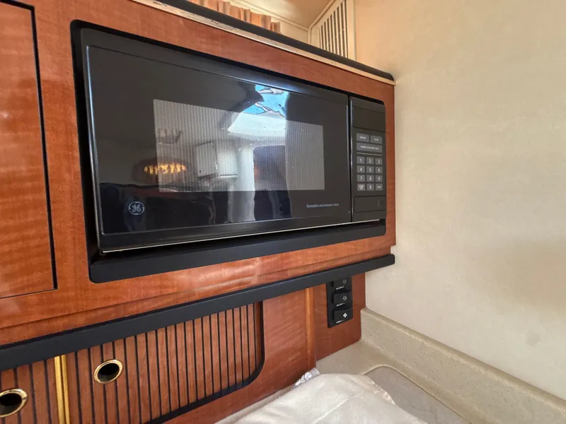 Slide: The Image of Microwave in 2001 Sea Ray 290 Sundancer boat interior, featuring wood paneling. - 31