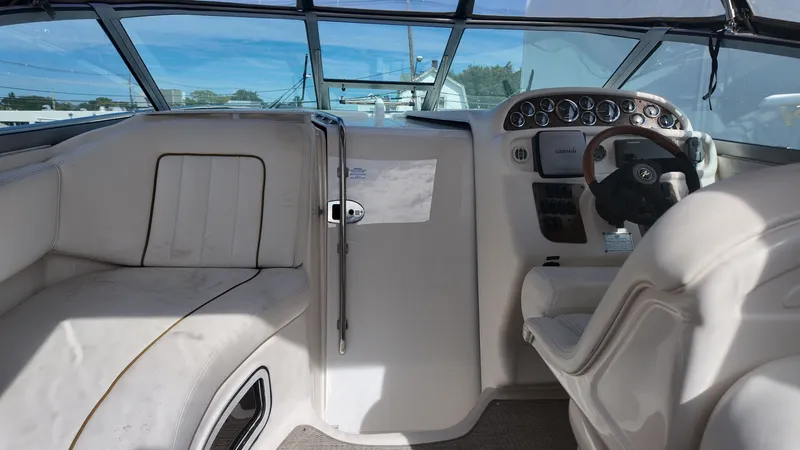 Slide: The Image of 2001 Sea Ray 290 Sundancer cockpit with steering wheel, gauges, and seating under clear blue sky. - 4