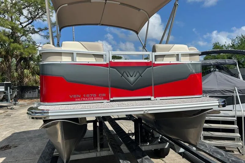Slide: The Image of 2025 Avalon VENTURE CRUISE pontoon boat, red and gray, docked under blue sky. - 2