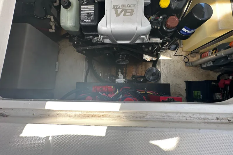 Slide: The Image of 2016 Monterey 295 Sport Yacht interior with open engine compartment, showcasing sleek white seating. - 102