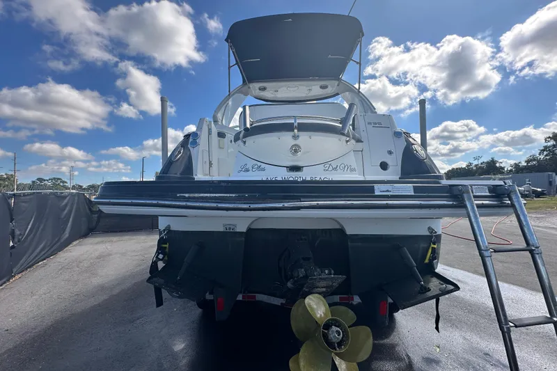 Slide: The Image of 2016 Monterey 295 Sport Yacht rear view with ladder and propeller, parked outdoors. - 11
