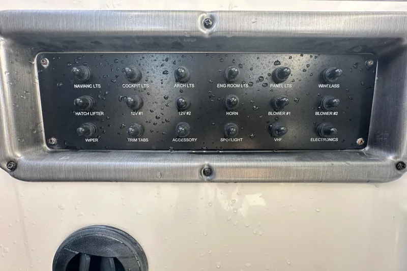 Slide: The Image of Control panel of a 2016 Monterey 295 Sport Yacht with labeled switches. - 48