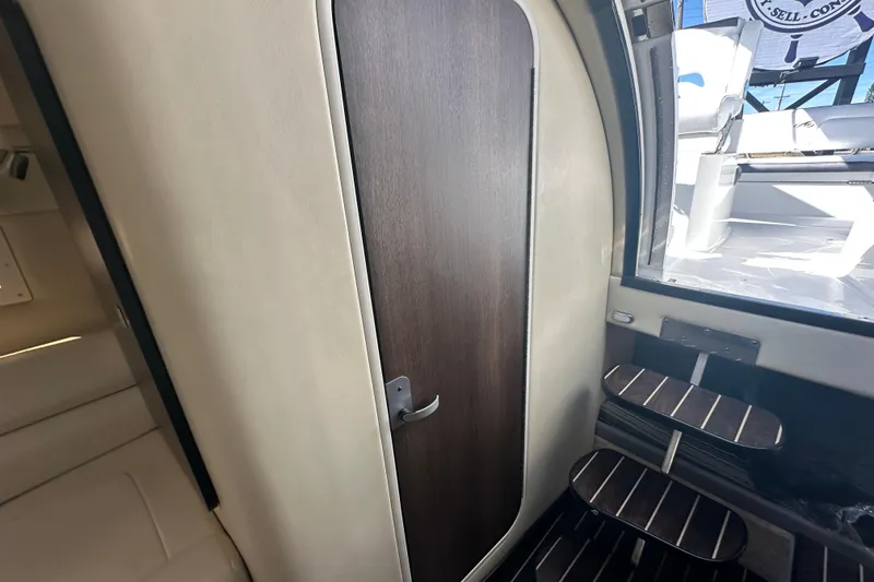 Slide: The Image of Interior of 2016 Monterey 295 Sport Yacht with beige seating and wooden accents. - 70