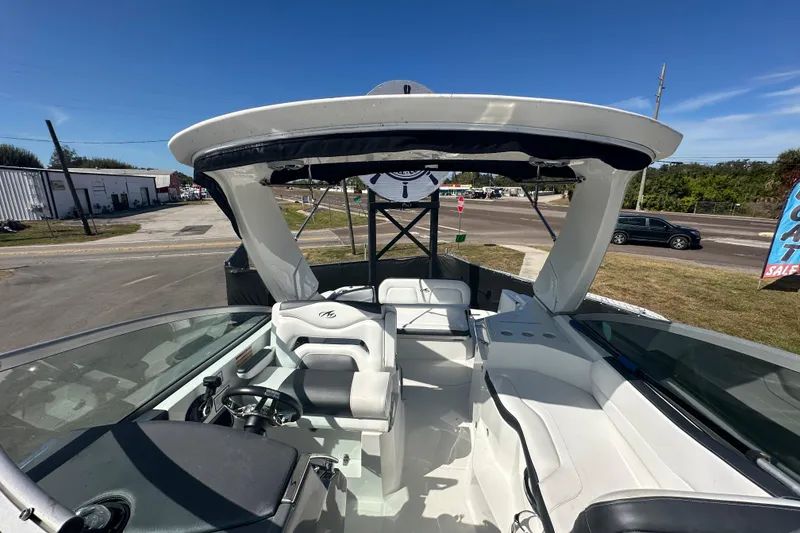 Slide: The Image of 2016 Monterey 295 Sport Yacht with open deck and windshield, parked near a road. - 87