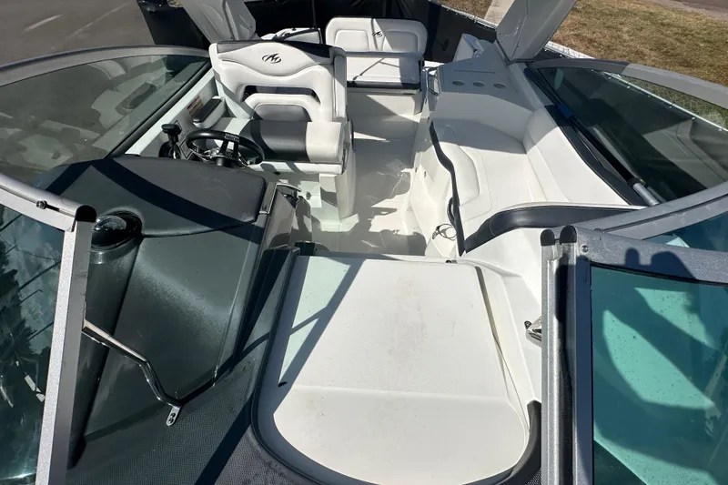 Slide: The Image of 2016 Monterey 295 Sport Yacht interior with seating and helm, parked outdoors under clear sky. - 89