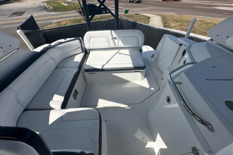 Slide: The Image of 2016 Monterey 295 Sport Yacht interior with canopy, parked near a road under clear blue skies. - 99
