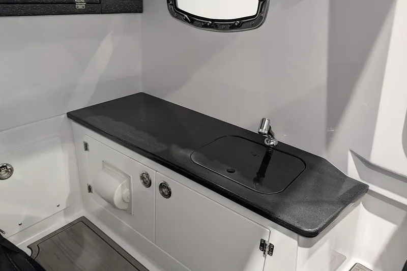 Slide: The Image of 2026 Monterey Elite 25 OB boat interior with sleek black countertop and modern sink. - 20