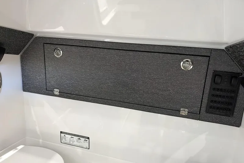 Slide: The Image of Interior view of 2026 Monterey Elite 25 OB boat with storage compartment and control panel. - 21
