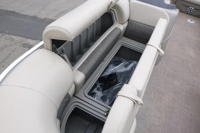 Slide: The Image of 2023 Sun Tracker Party Barge 20 DLX interior seating with storage compartment open. - 21