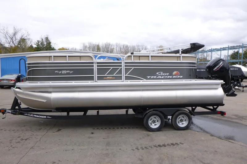 Slide: The Image of 2023 Sun Tracker Party Barge 20 DLX pontoon boat on trailer, parked outdoors. - 3