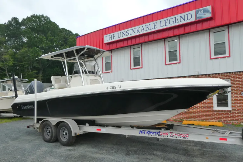 The Image of 2012 ShearWater 26 boat on trailer outside "The Unsinkable Legend" building. - 1