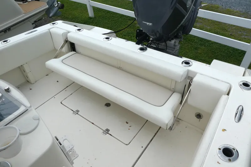 Slide: The Image of 2012 ShearWater 26 boat interior with cushioned seating and outboard motor. - 10