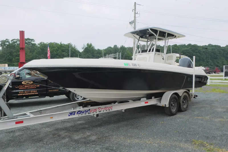 Slide: The Image of 2012 ShearWater 26 boat on trailer, black hull, parked outdoors. - 4