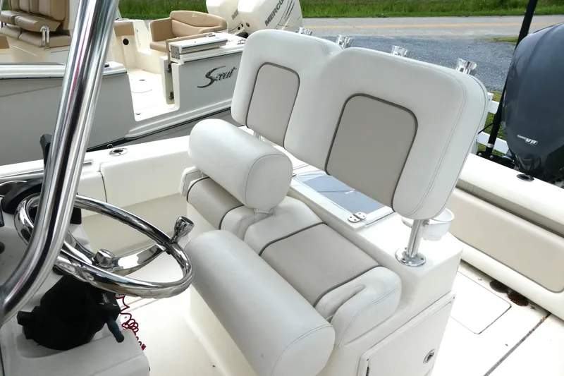 Slide: The Image of 2012 ShearWater 26 boat interior with steering wheel and cushioned seating. - 8