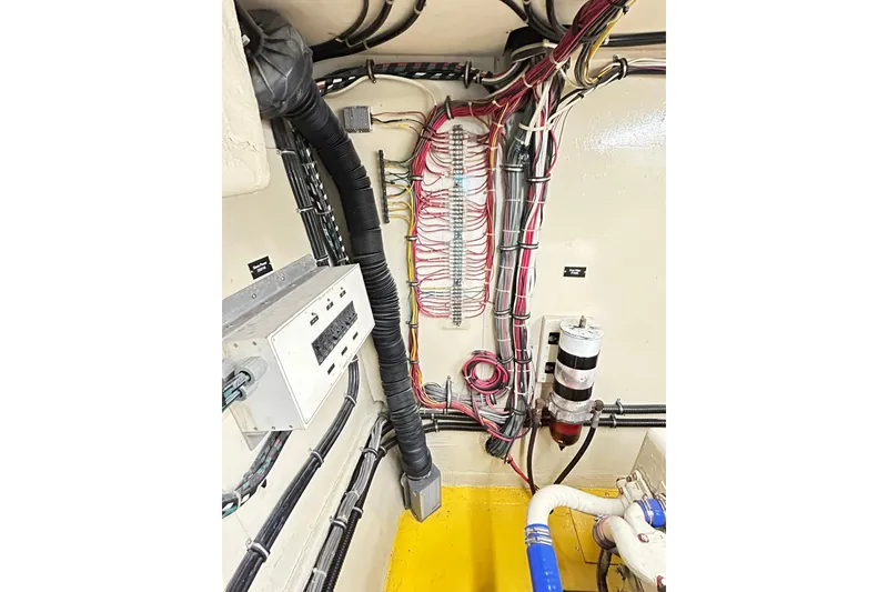 Slide: The Image of Engine room wiring of 1979 Hatteras 53 Motor Yacht Hard Top, showcasing cables and components. - 100