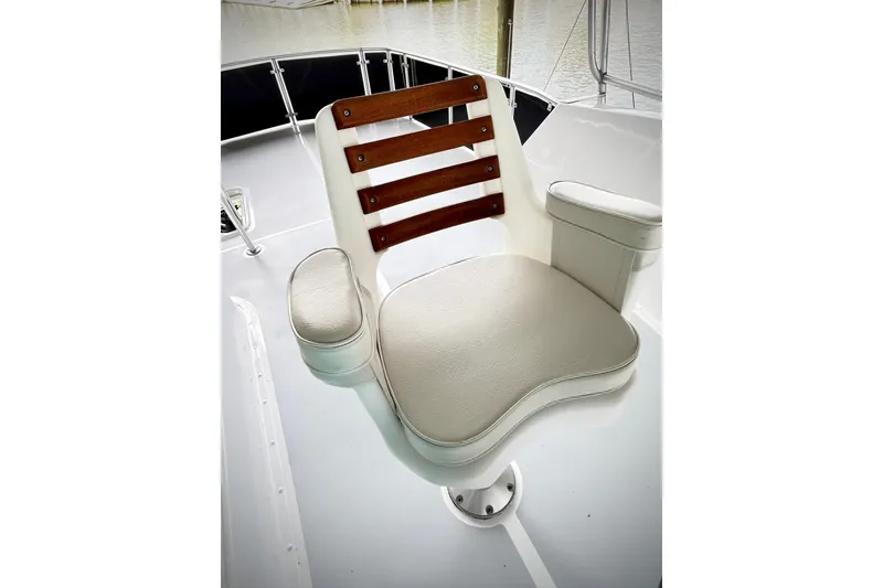 Slide: The Image of Captain's chair on 1979 Hatteras 53 Motor Yacht Hard Top, featuring wooden accents. - 106