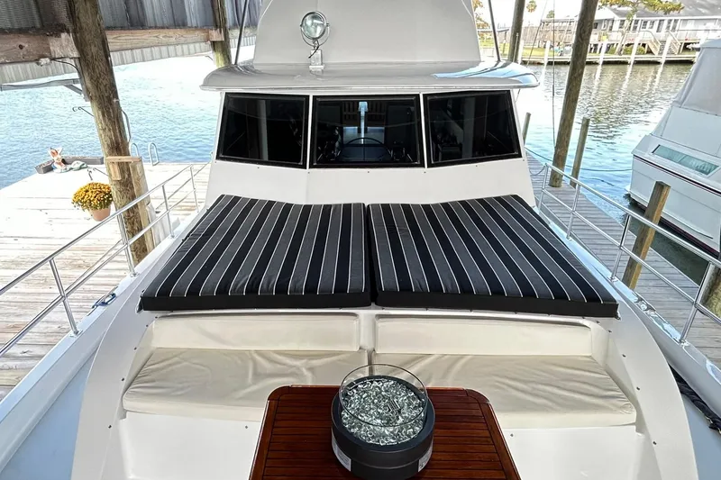 Slide: The Image of 1979 Hatteras 53 Motor Yacht Hard Top with striped cushions and wooden deck detail. - 110