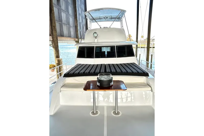 Slide: The Image of 1979 Hatteras 53 Motor Yacht Hard Top with seating and table on deck. - 114