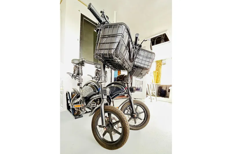 Slide: The Image of Two black bicycles with front baskets in a bright indoor setting. - 122