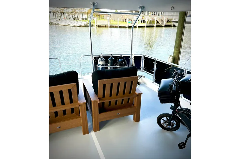 Slide: The Image of 1979 Hatteras 53 Motor Yacht deck with chairs and a bicycle. - 124