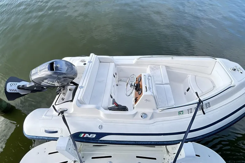 Slide: The Image of Aerial view of a white motorboat with Yamaha engine, docked on calm water. - 137