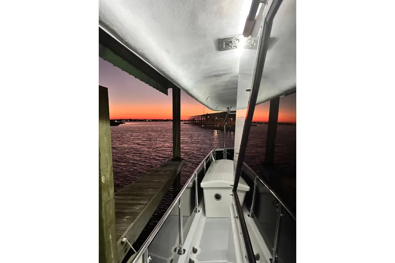 Slide: The Image of 1973 Hatteras 53 Motor Yacht at sunset, docked with vibrant sky in background. - 141