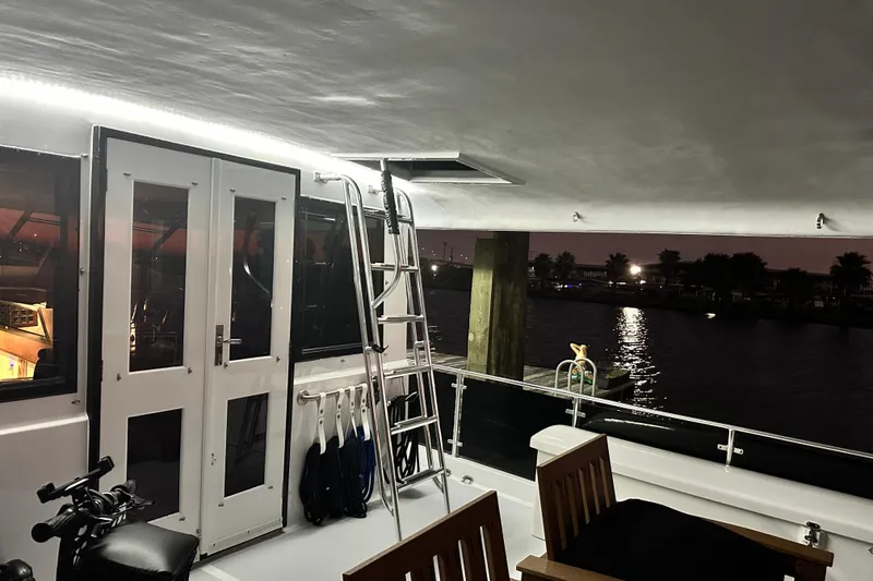 Slide: The Image of 1973 Hatteras 53 Motor Yacht Hard Top at night, featuring a sleek interior and exterior view. - 154