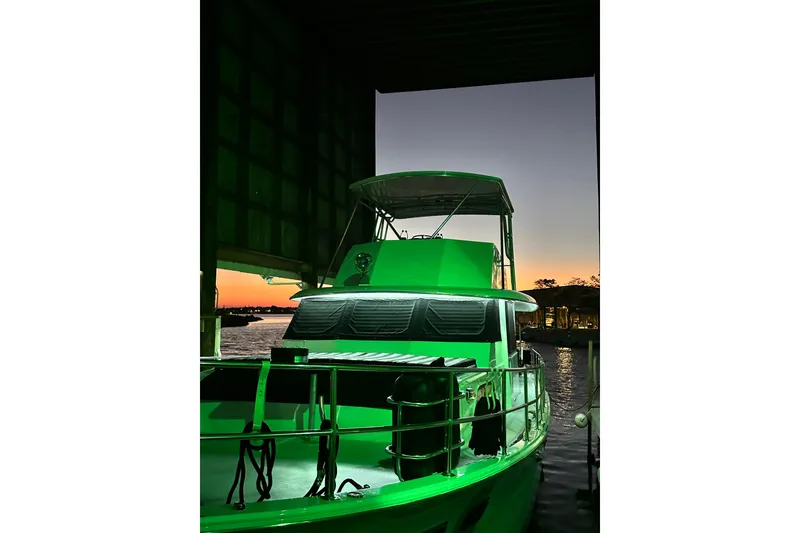 Slide: The Image of 1973 Hatteras 53 Motor Yacht Hard Top illuminated at sunset in a marina. - 159