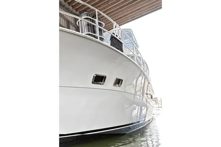 Slide: The Image of 1979 Hatteras 53 Motor Yacht Hard Top docked under a wooden structure. - 16