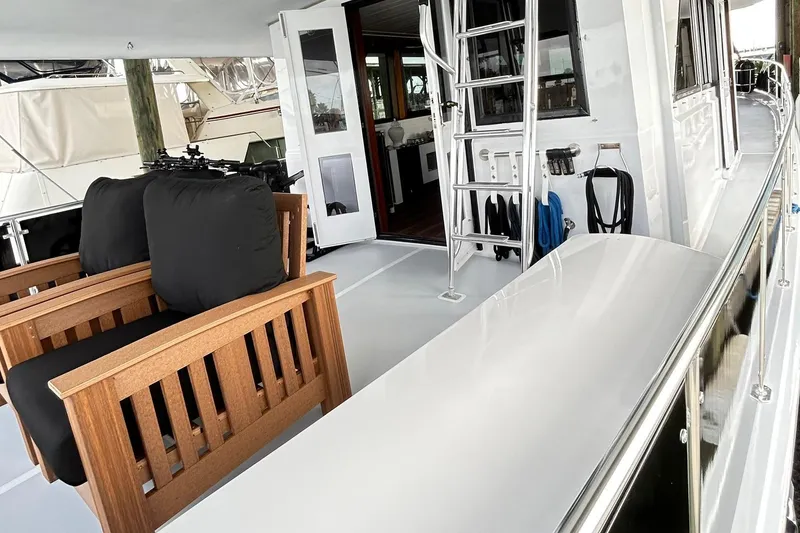 Slide: The Image of 1979 Hatteras 53 Motor Yacht Hard Top with wooden seating and sleek deck design. - 17