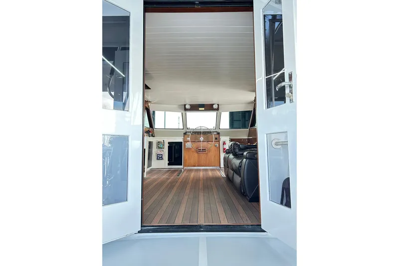Slide: The Image of Interior view of 1979 Hatteras 53 Motor Yacht Hard Top, featuring wooden flooring and helm. - 19