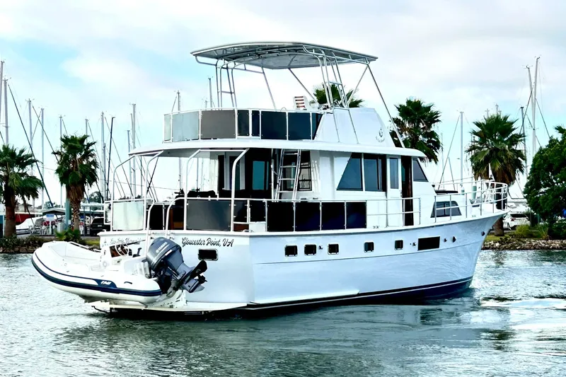 Slide: The Image of 1979 Hatteras 53 Motor Yacht Hard Top cruising near marina with palm trees. - 2