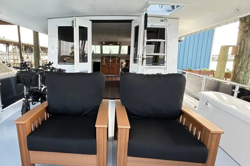 Slide: The Image of 1979 Hatteras 53 Motor Yacht Hard Top with black cushioned chairs on deck. - 34