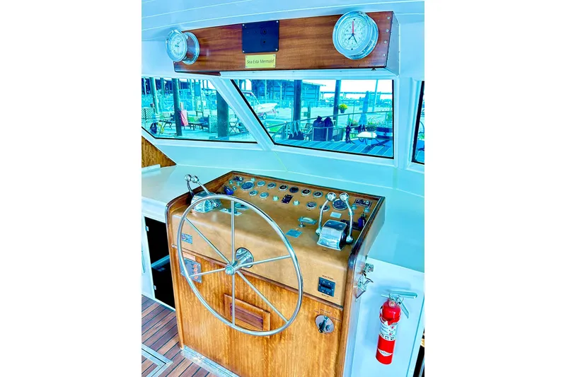 Slide: The Image of 1979 Hatteras 53 Motor Yacht helm with wooden wheel and gauges, dock view. - 36