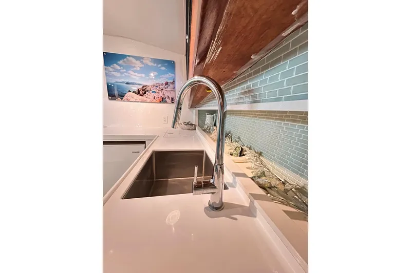 Slide: The Image of Modern kitchen sink on 1979 Hatteras 53 Motor Yacht, featuring sleek faucet and backsplash. - 49