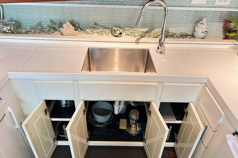 Slide: The Image of 1979 Hatteras 53 Motor Yacht kitchen with stainless steel sink and open cabinets. - 51