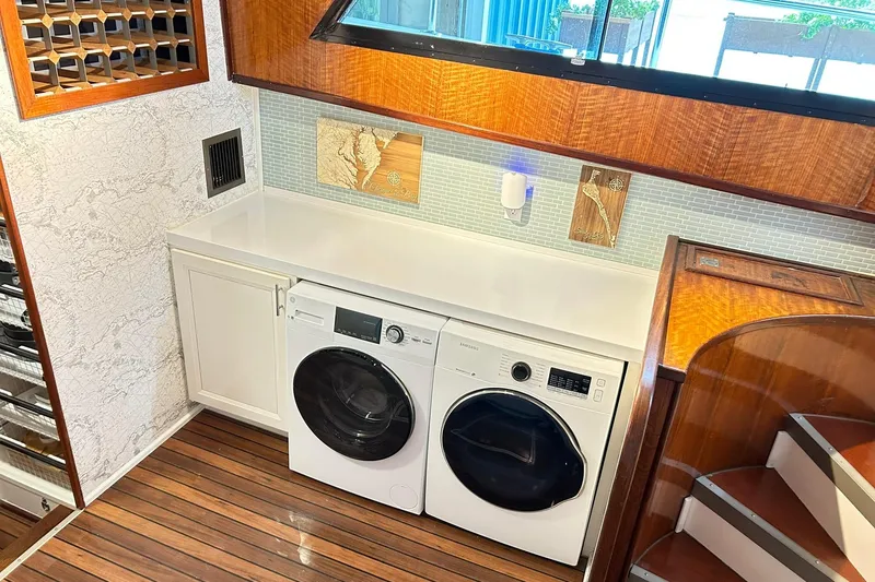 Slide: The Image of Laundry area on 1979 Hatteras 53 Motor Yacht with washer, dryer, and wooden accents. - 52