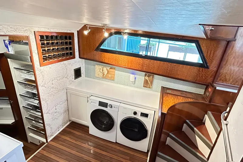 Slide: The Image of Interior of 1979 Hatteras 53 Motor Yacht with laundry area and wooden staircase. - 54