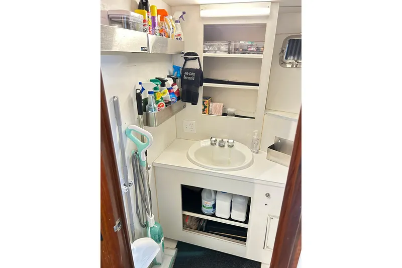 Slide: The Image of 1979 Hatteras 53 Motor Yacht bathroom with cleaning supplies and sink. - 60