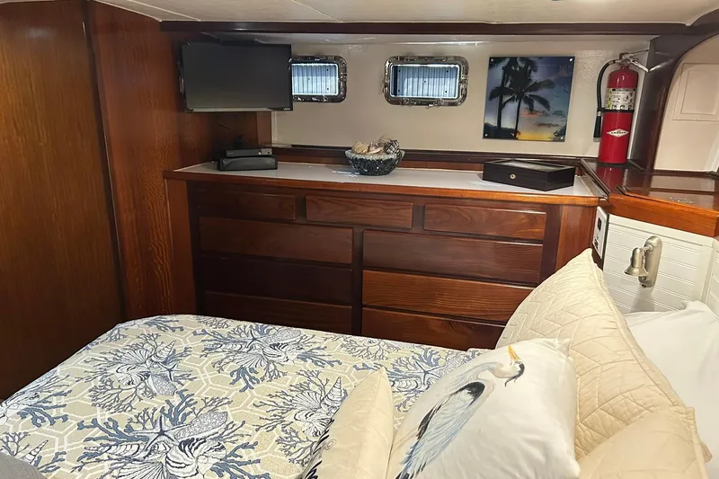 Slide: The Image of Cozy cabin interior of 1979 Hatteras 53 Motor Yacht with wood finish and decorative bedding. - 65