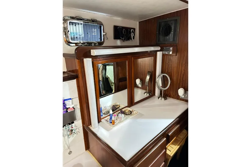 Slide: The Image of 1979 Hatteras 53 Motor Yacht vanity area with mirrors and wooden cabinetry. - 74