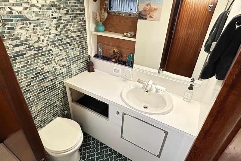 Slide: The Image of Bathroom interior of 1979 Hatteras 53 Motor Yacht, featuring modern sink and mosaic tile wall. - 76
