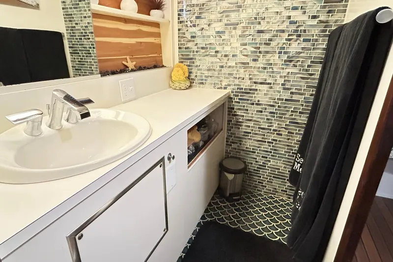 Slide: The Image of Bathroom interior of 1979 Hatteras 53 Motor Yacht, featuring modern sink and mosaic tiles. - 84