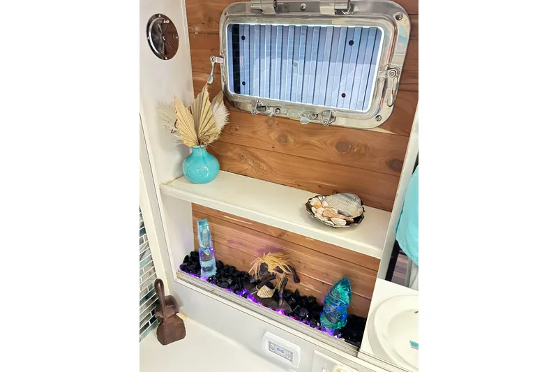 Slide: The Image of 1979 Hatteras 53 Motor Yacht interior with decorative shelf, seashells, and turquoise vase. - 85