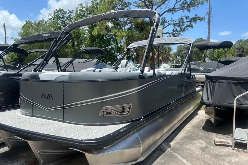 Slide: The Image of 2025 Avalon LSZ Cruise Rear Bench pontoon boat in a sunny outdoor setting. - 1