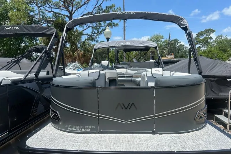 Slide: The Image of 2025 Avalon LSZ Cruise Rear Bench pontoon boat, saltwater series, in a marina setting. - 3