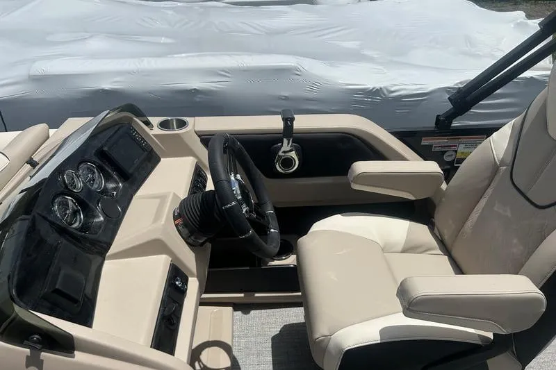Slide: The Image of 2025 Avalon LSZ Versatile Rear Bench boat interior with steering wheel and beige seating. - 5